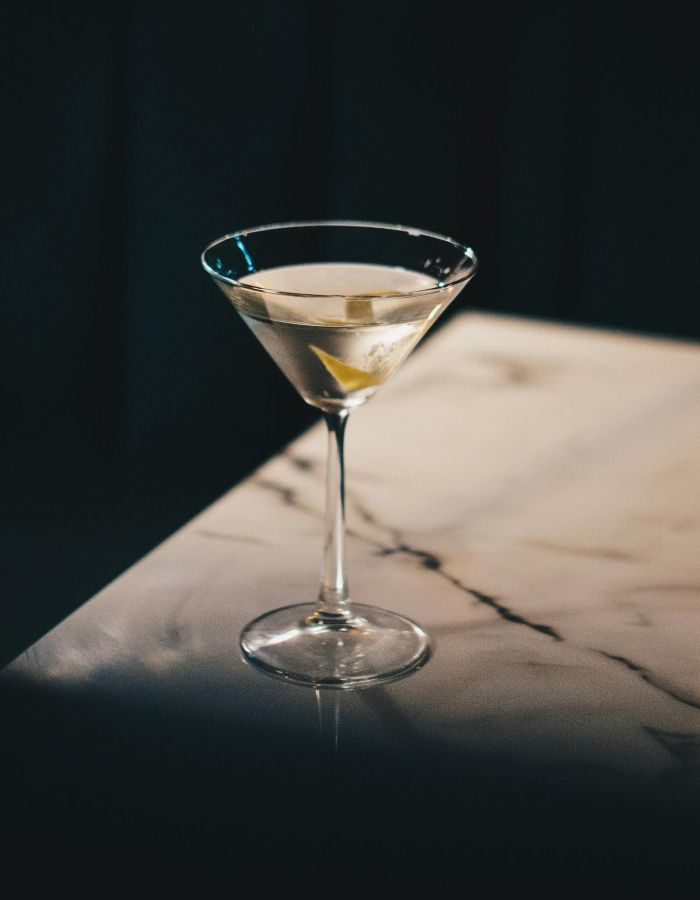 Oberon A martini served in a glass, elegantly placed on a polished table surface.
